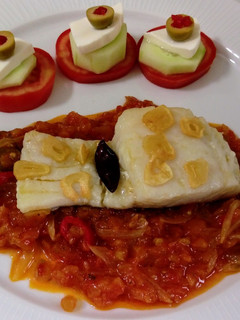 Una foto de Bacalao al ajillo con salsa de tomate y pinchitos de tomate