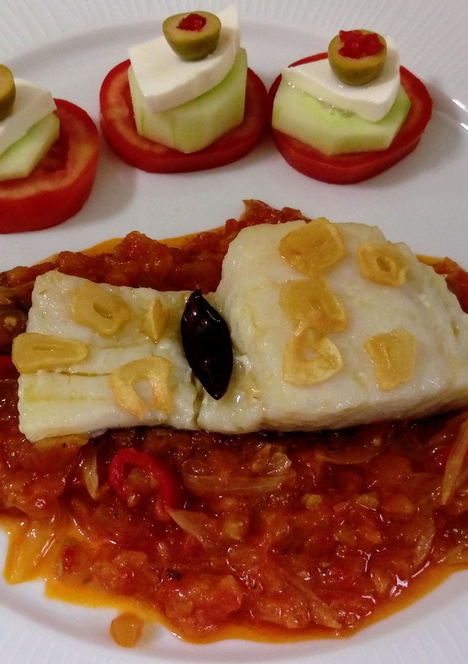 Una foto de Bacalao al ajillo con salsa de tomate y pinchitos de tomate