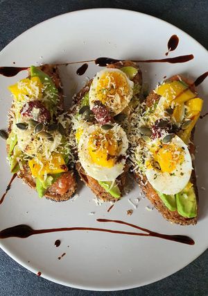 Une photo de Tartines pan con tomate, avocado, mangue et œufs