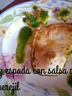 Una foto de Pez espada con salsa de ajo y perejil