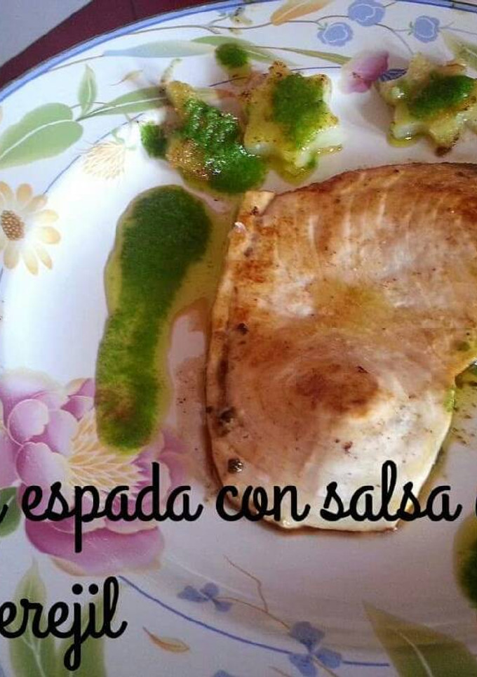 Una foto de Pez espada con salsa de ajo y perejil