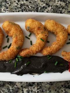 Una foto de Langostinos crujientes con crema de ajo negro