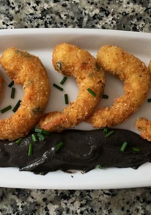 Una foto de Langostinos crujientes con crema de ajo negro