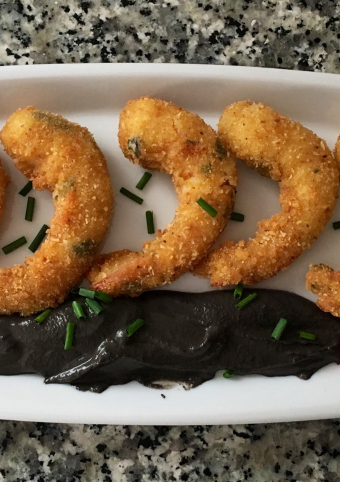 Una foto de Langostinos crujientes con crema de ajo negro