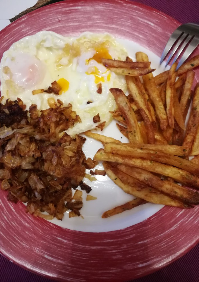 Una foto de Huevos fritos con patatas y cebolla