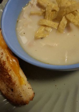 A picture of Grilled cheese and creamy chicken soup.
