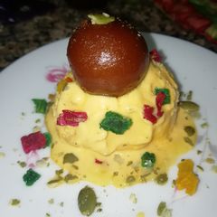 A picture of Mango Icecream with gulab jamun.
