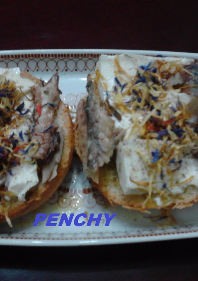 Una foto de Tostas de pan, con queso fresco, caballa y petalos de flores