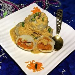 A picture of Stuffed rice dumpling in rabri sauce.