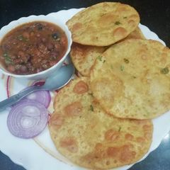 A picture of Aloo Palak Puri with Chana Masala jhor.