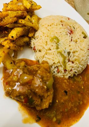 A picture of Spicy chicken machurian with fried rice and masala fries.