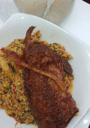 A picture of Egusi soup with bitter leaves and fish.