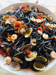 Una foto de Espaguetis negros con gambas y almejas 🍝