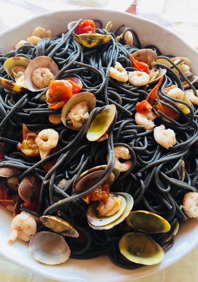 Una foto de Espaguetis negros con gambas y almejas 🍝