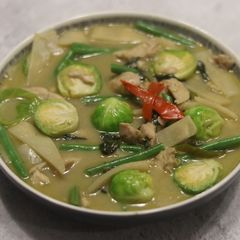 A picture of Thai green curry with brussel sprouts.