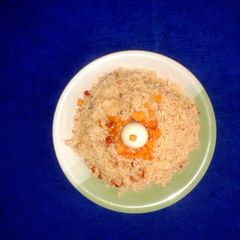 A picture of Jollof rice with boiled rice egg.
