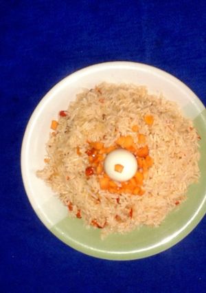 A picture of Jollof rice with boiled rice egg.