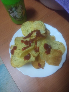 Una foto de Papas onduladas fritas al ajillo con ketchup