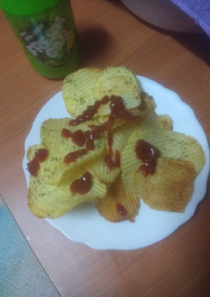 Una foto de Papas onduladas fritas al ajillo con ketchup