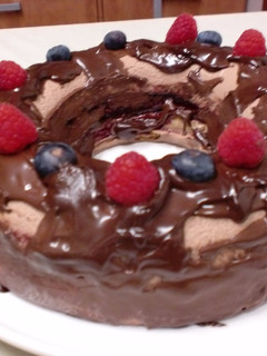 Una foto de Corona de mousse de chocolate con leche, mousse de frambuesa y mermelada de arándanos