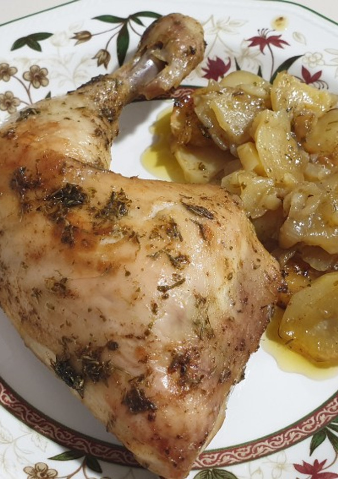 Una foto de Cuartos traseros de pollo al horno con patatas panaderas