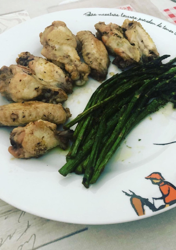 Una foto de Alitas de pollo con espárragos salteados