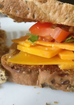 A picture of Cheese & Tomato sandwich with basil.