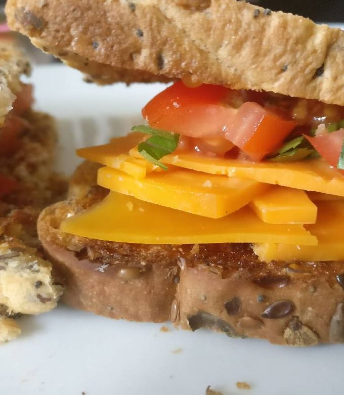 A picture of Cheese & Tomato sandwich with basil.