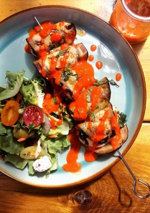 A picture of Salmon,aubergine and spinach skewers with red pepper dressing.