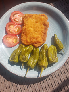 Una foto de 🐷 Lomo empanado 🥖 con queso 🧀 y pimientos 🫑 del Padrón