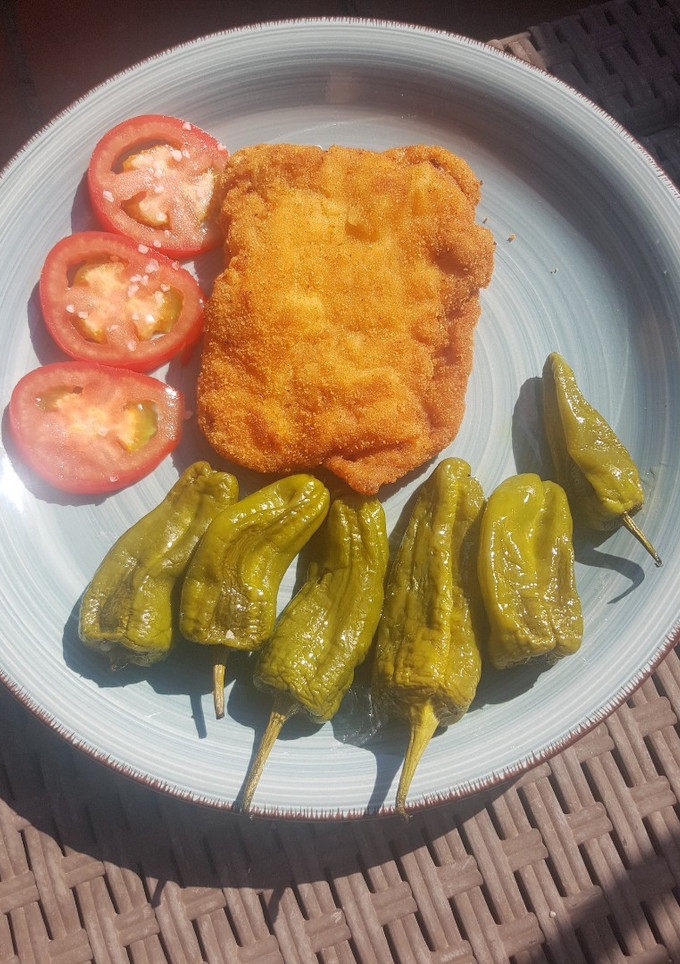 Una foto de 🐷 Lomo empanado 🥖 con queso 🧀 y pimientos 🫑 del Padrón
