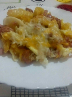 Una foto de Patatas con beicon, jamón york, salchichas y huevos rotos con queso y gratinado