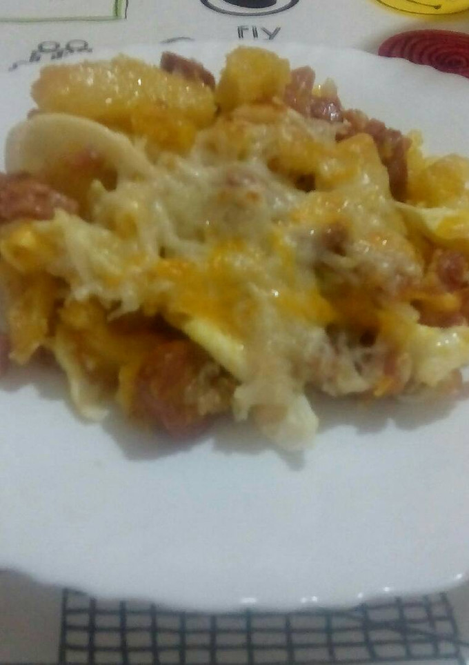 Una foto de Patatas con beicon, jamón york, salchichas y huevos rotos con queso y gratinado