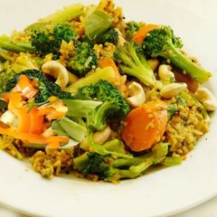 A picture of Multi colored pilaf with broccoli, red and orange bell peppers, and carrots.