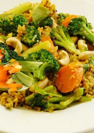A picture of Multi colored pilaf with broccoli, red and orange bell peppers, and carrots.