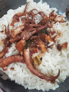 Una foto de Tentáculos de calamar con arroz y salsa de aderezos