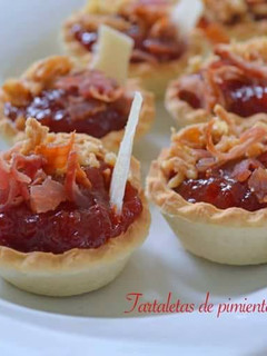 Una foto de Tartaletas de pimientos confitados con crujiente de beicon, cebolla frita y parmesano
