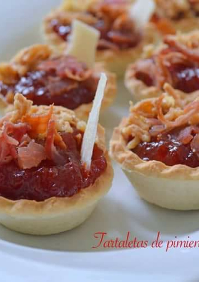 Una foto de Tartaletas de pimientos confitados con crujiente de beicon, cebolla frita y parmesano