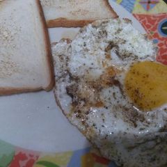 A picture of Half fry Egg with toast.