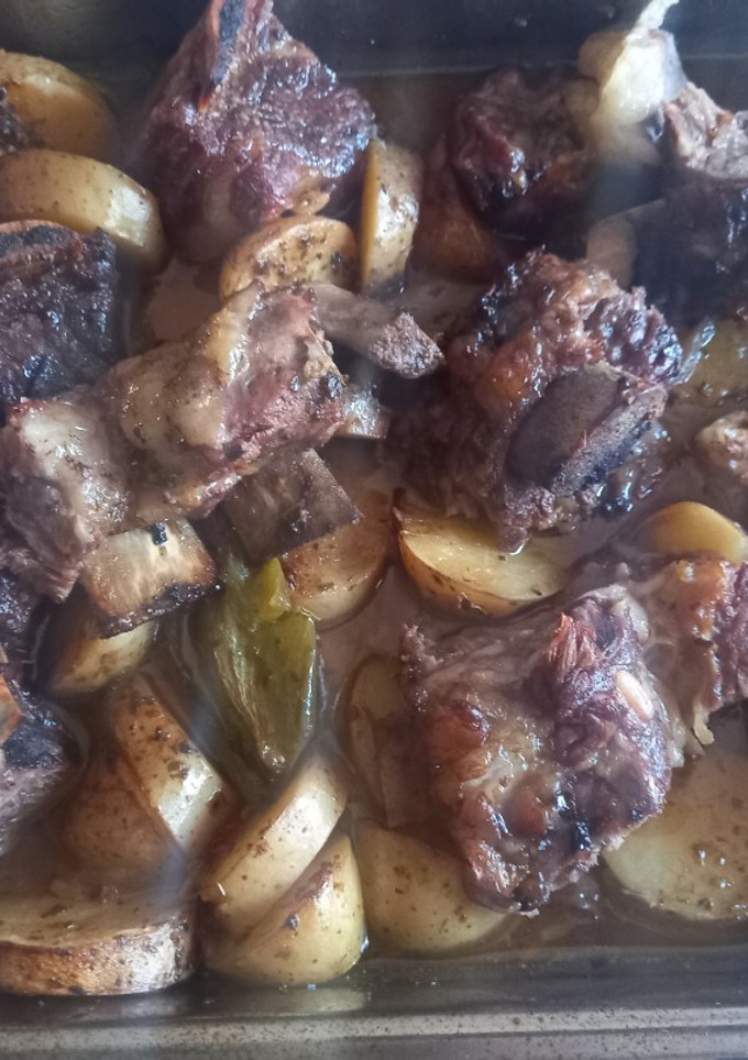Una foto de Tira de Asado al Horno con Papas, Morrones y Cebollas