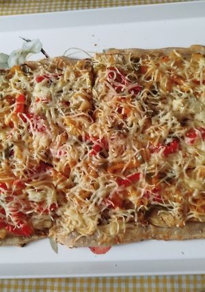 Una foto de Masa de pizza con multisemillas casera con queso de untar y verduras