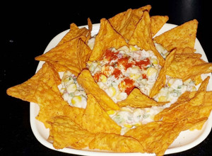 A picture of Mexican corn salad with nachos.