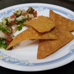 A picture of Nachos with salsa.