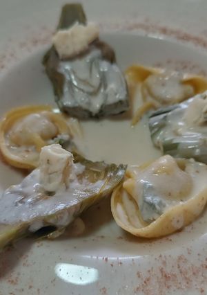 Una foto de Raviolis rellenos de queso con alcachofas y salsa de roquefort