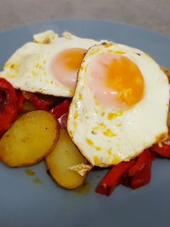 Una foto de Papas a lo pobre con huevos fritos