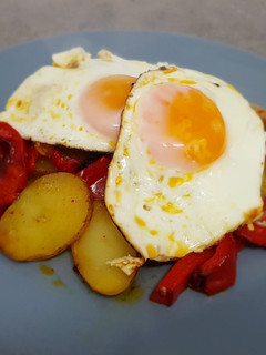 Una foto de Papas a lo pobre con huevos fritos