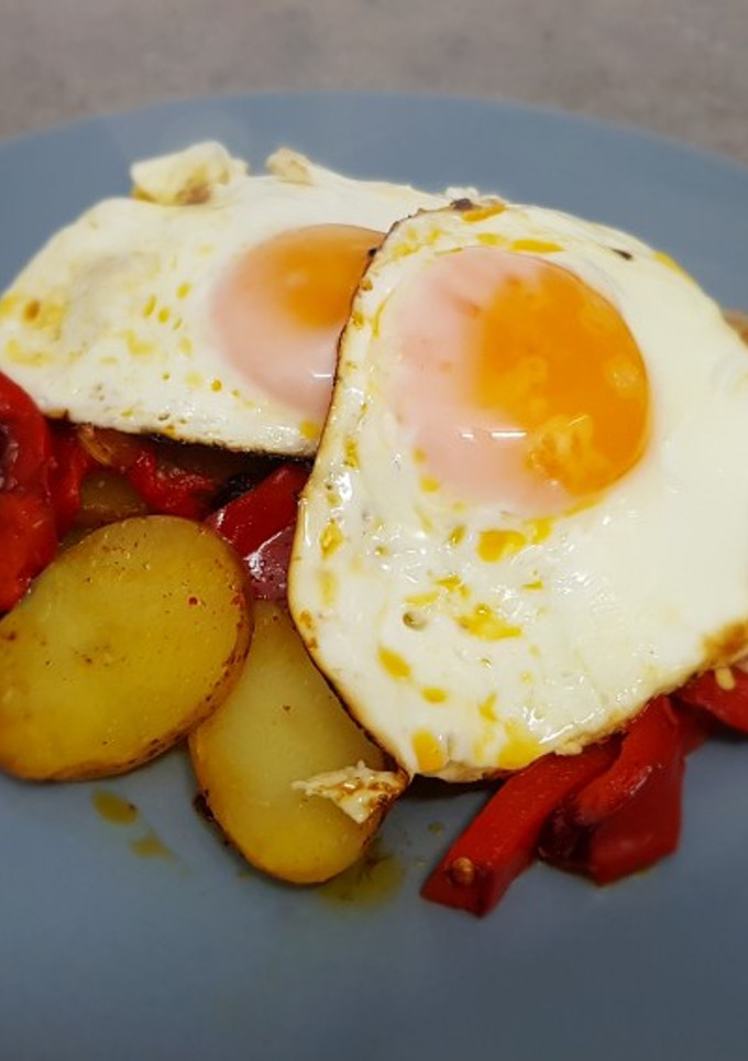 Una foto de Papas a lo pobre con huevos fritos