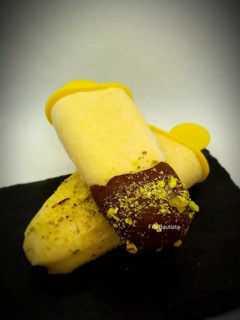 Una foto de Polos de mango y leche de coco con chocolate y pistachos