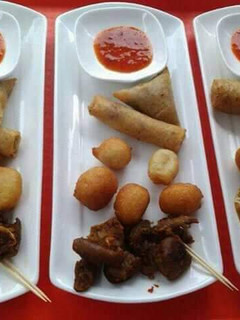 A picture of Puff puff, spring rolls, samosa and fried meat.