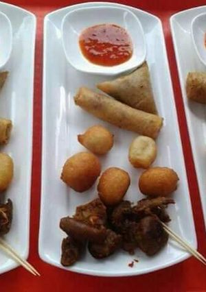 A picture of Puff puff, spring rolls, samosa and fried meat.